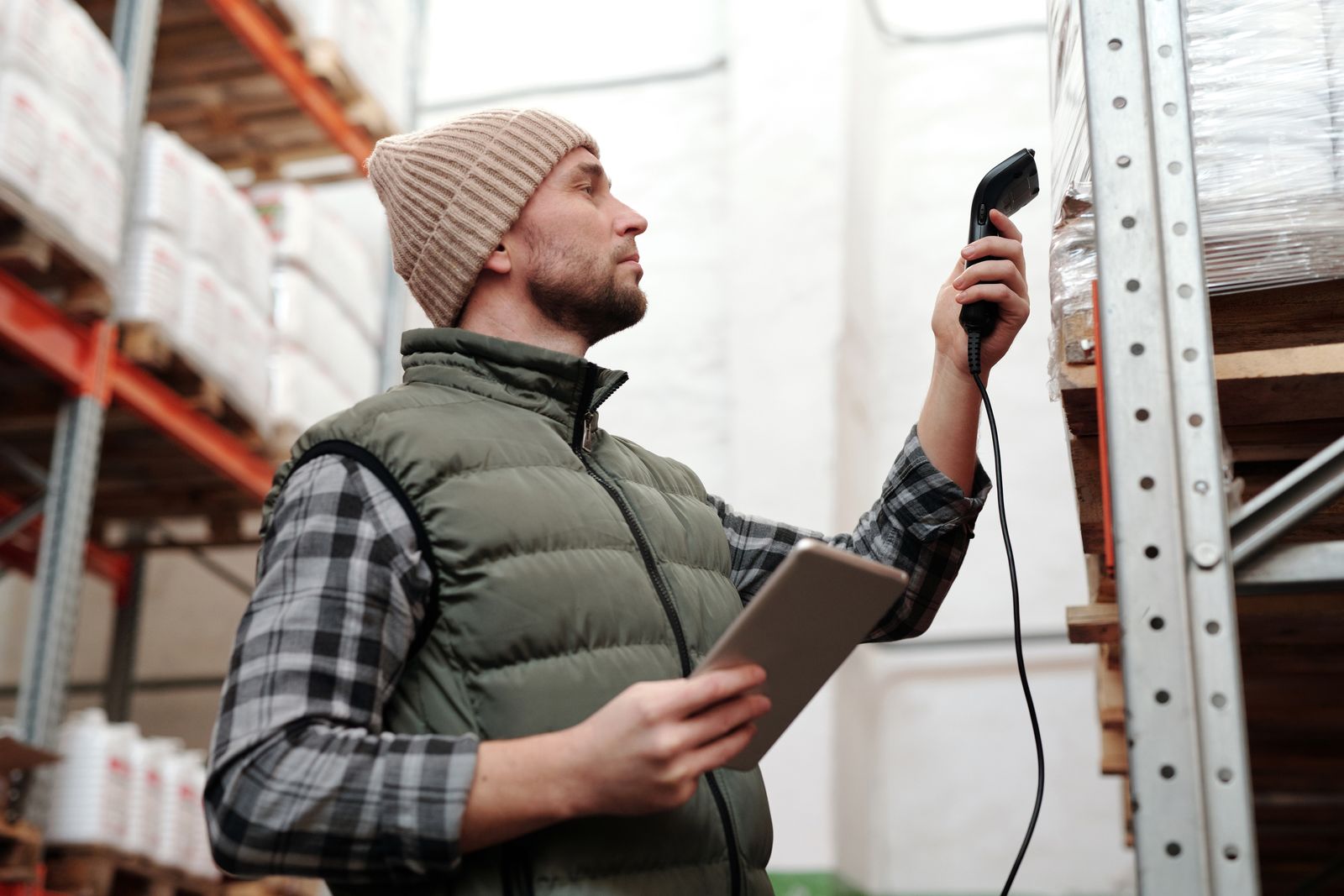 Stock photograph of a warehouse worker scanning packaged inventory